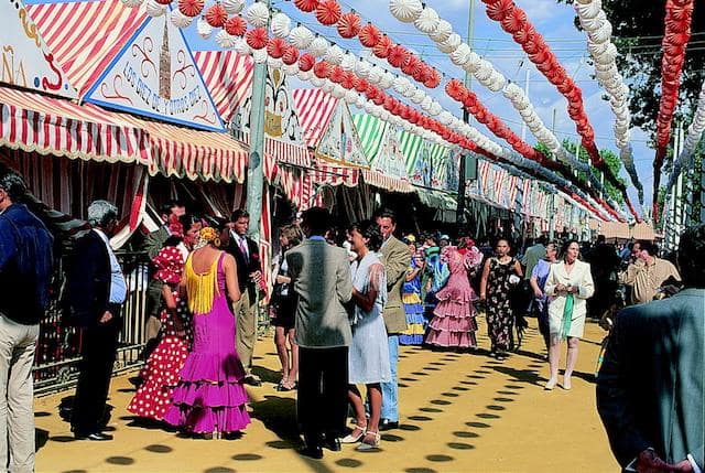 Casetas e pessoas com trajes na Feria de Sevilha